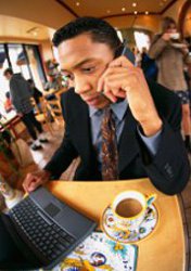 man in cafe with laptop and mobile phone