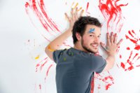man painting hand prints on wall