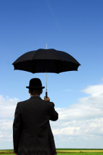 man holding umbrellal under clear blue sky
