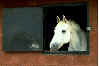 white horse looking over stable door